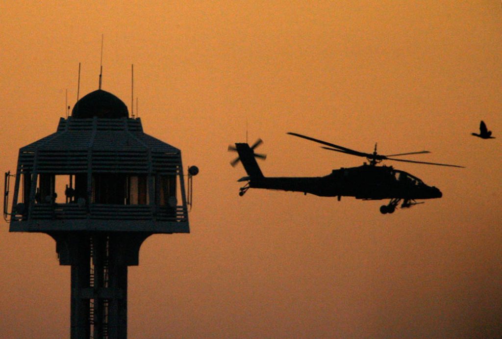 The sun sets as an U.S. Apache helicopter takes off from the Green Zone to patrol over Baghdad
